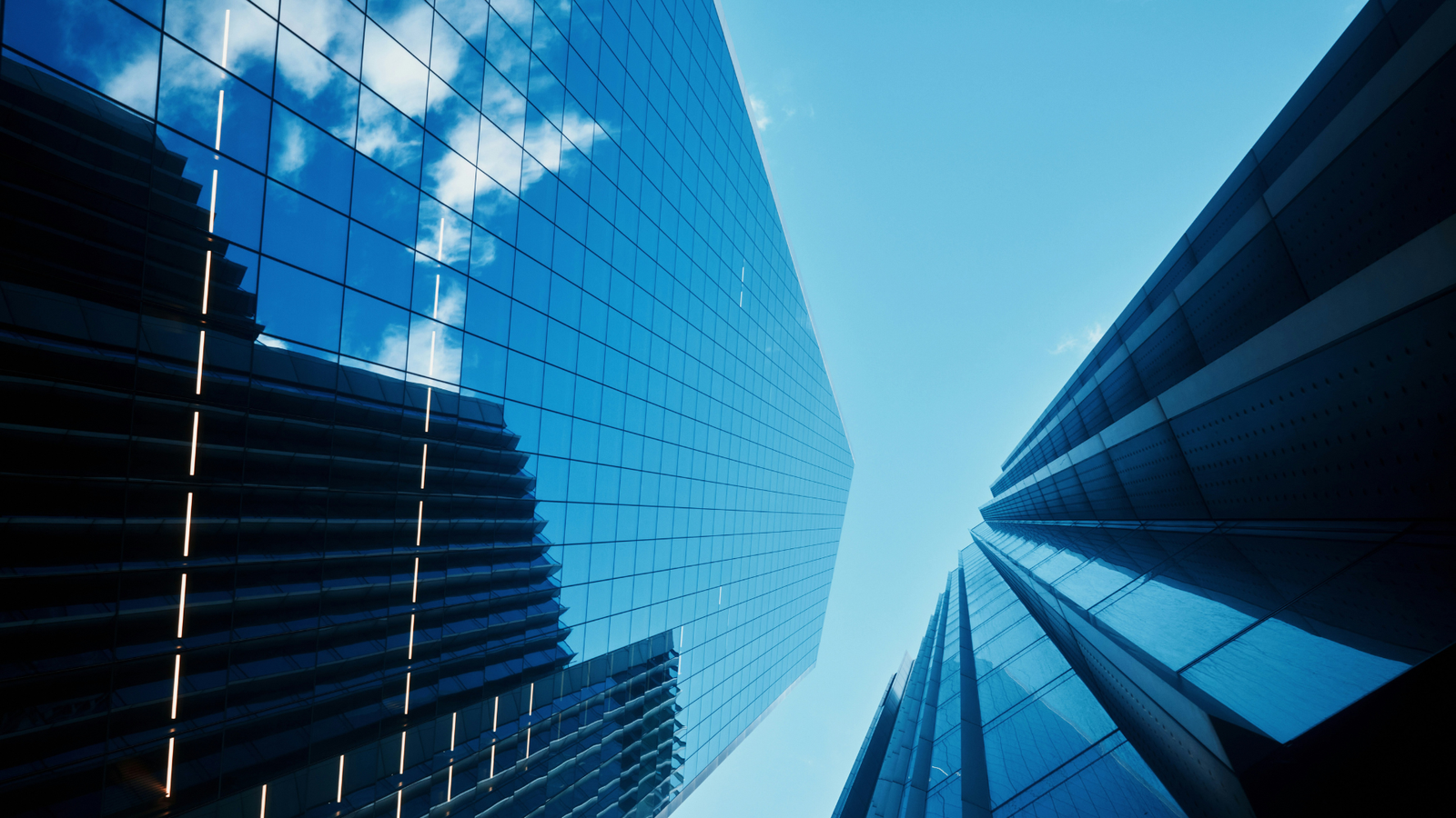 An image showing a view of two tall buildings from a ground up perspective.