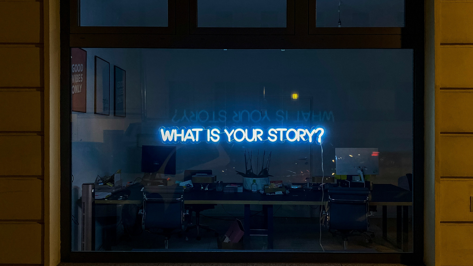 Sustainability Content Writing - An image of a window with a neon sign that says 'What is Your Story?'
